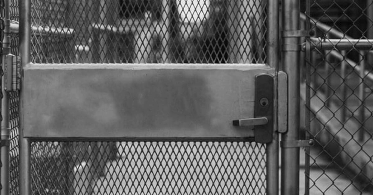 12 Most Frequently Asked Questions About Bail Bonds - Locked gate leading to the outside - Photo by Najib Kalil on Unsplash